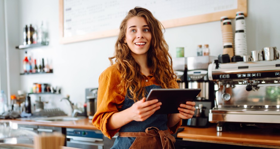 l&auml;chelnde Frau in ihrem Gastronomiebetrieb