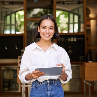 Frau vor Restaurant, die den Grundkurs Gastronomief&uuml;hrung abgeschlossen hat